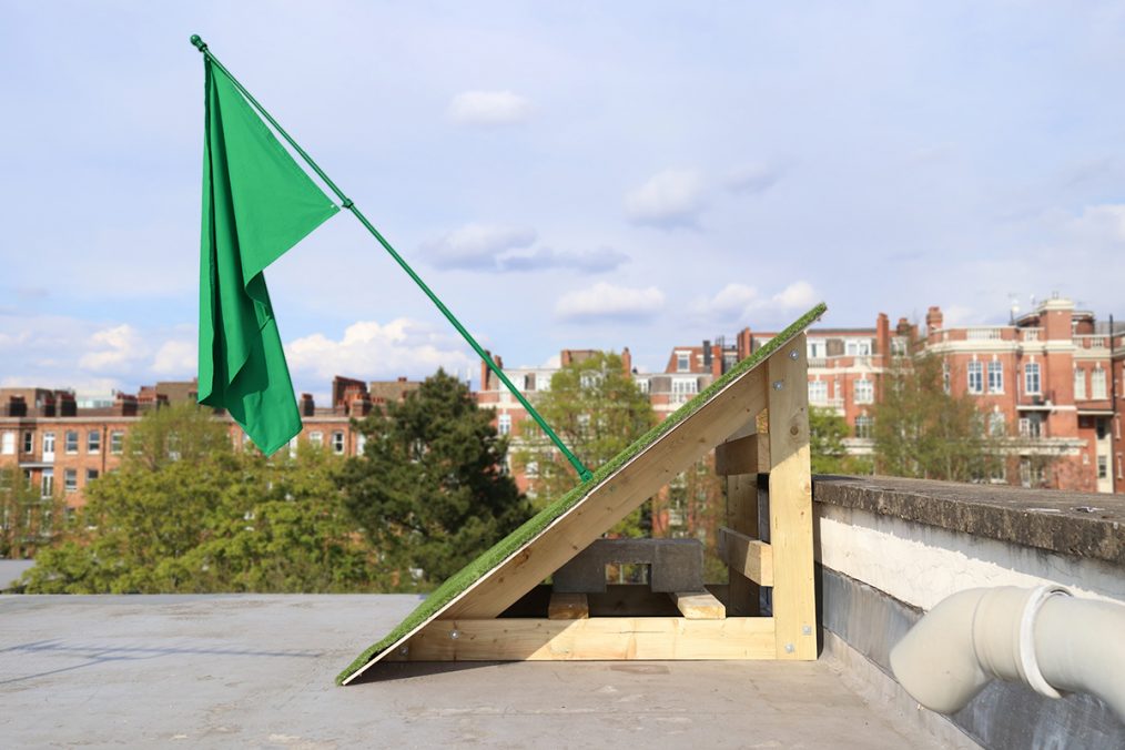 Allegory. Flag, flag pole, artificial grass, wooden structure 2021